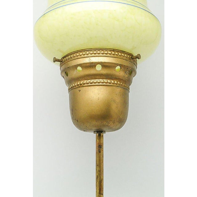 The pendant lamp was produced in the 1950s. It is made in the art deco style. The structure is made of brass and the...