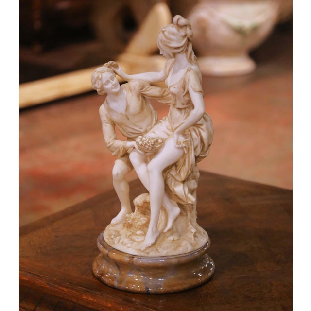 This refined mid-century Italian alabaster sculpture depicts a romantic Neoclassical figural group rendered with graceful...