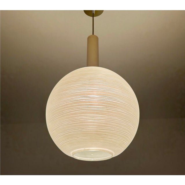 Mid century pendant light featuring a pastel green glass globe shade with whirlwind pinstriped pattern, brass glass cap,...