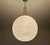 Mid century pendant light featuring a pastel green glass globe shade with whirlwind pinstriped pattern, brass glass cap,...