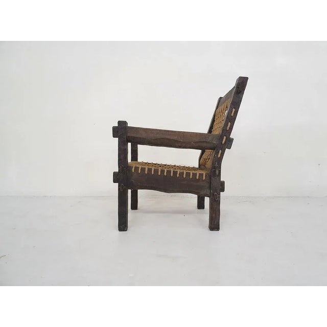 Beautifuly carved wooden lounge chair with rope seating and back.