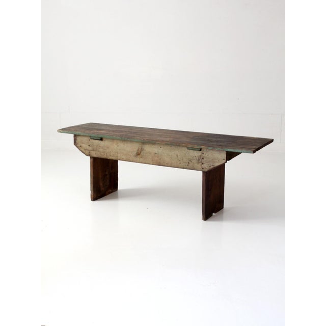 Antique primitive farmhouse bench with original green and cream paint, a beautifully weathered plank top, broad wood legs,...