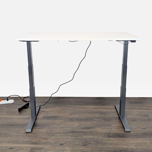 This Steelcase desk features a clean white top and sturdy gray legs. It is electric height adjustable, allowing you to...