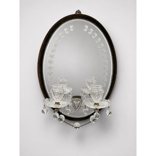 A rare and highly decorative pair of Victorian mirrored oil sconces, each with an oval beveled mirror plate set within a...