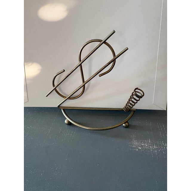 Fun and sculptural vintage brass dollar sign bill holder dating to the mid-20th century. The dimensional wire design forms...