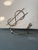 Fun and sculptural vintage brass dollar sign bill holder dating to the mid-20th century. The dimensional wire design forms...