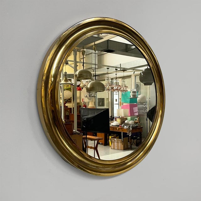 Italian mid-century modern round wall mirror in brass, 1950s Round wall mirror with brass frame. The frame features a...