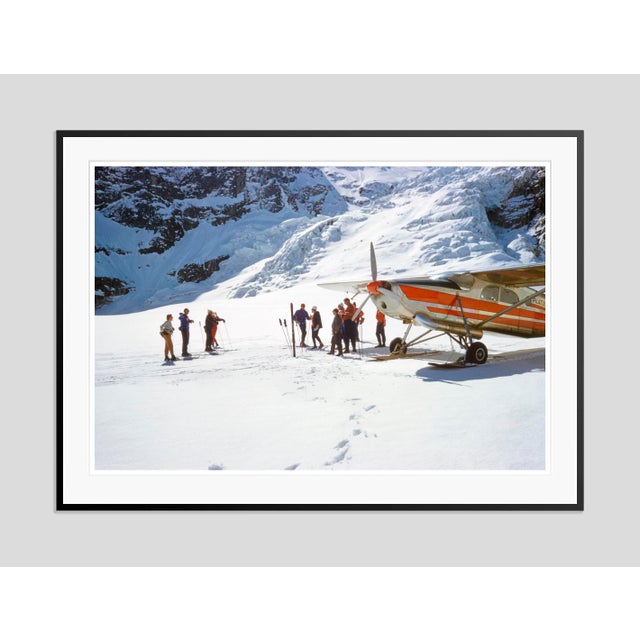 Ski Plane by Toni Frissell A group of skiers wait by the side of a ski plane at the bottom of a piste in Switzerland....