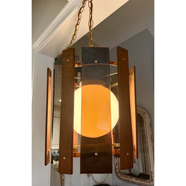 This mid‑century teak and smoked acrylic swag lamp is a sculptural statement piece that captures the warm, organic...