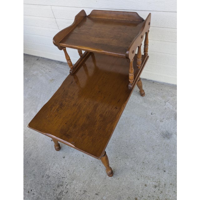 This is a mid-century wooden end table/side table featuring a tiered top, base shelf and turned legs. sturdy and in good...