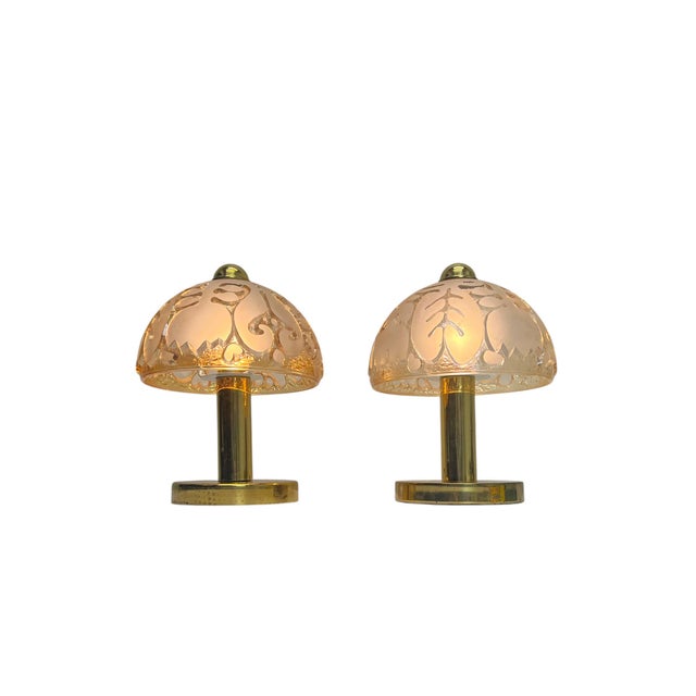 A charming set of small table or bedside lamps made of brass with thick glass shades featuring embossed floral designs....