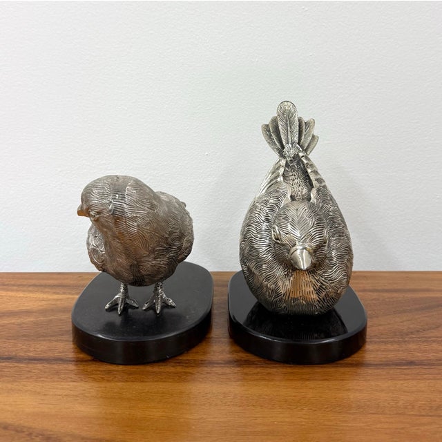 A charming pair of solid metal bird sculptures, each rendered with highly detailed feathering and expressive naturalistic...