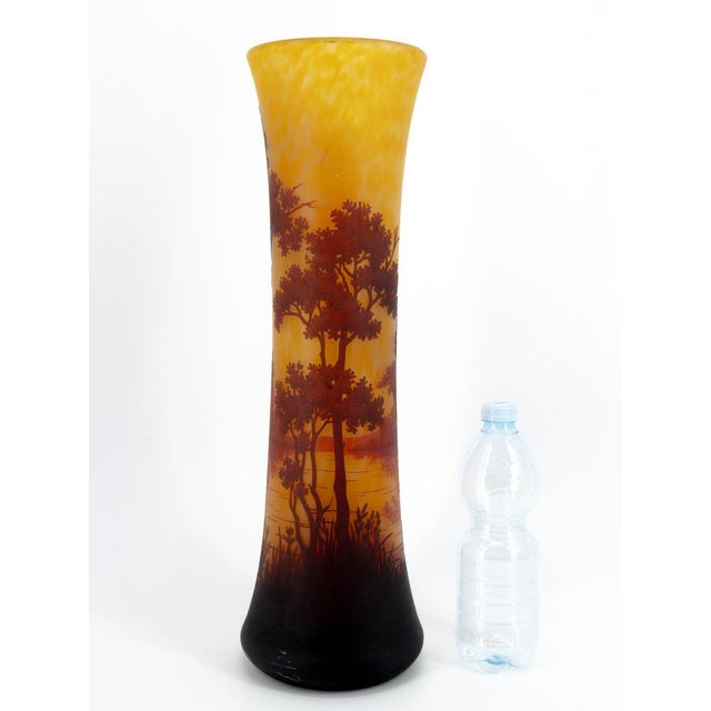 A striking and imposing multilayered glass vase with a slender trumpet shape, a masterpiece from the Daum Manufacture in...