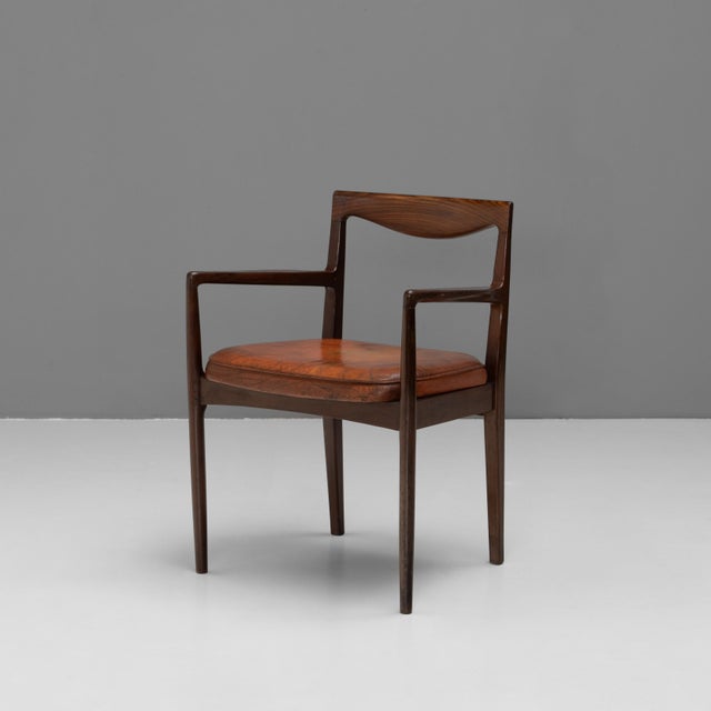 Mid-Century armchair in solid teak with original burnt orange leather seat pad. The chair has a good level of patina on...