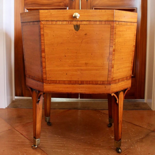 An inlaid satinwood Georgian cellarette with elegant inlaid sides and top: tulipwood cross banding and ebonized stringing...
