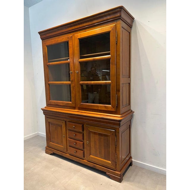 Beautiful vintage two-piece cabinet in solid wood, featuring a warm honey-toned finish and timeless classic design. This...