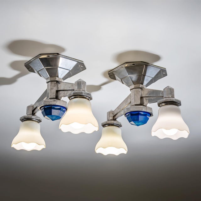 Set of four large ceiling lights in chrome-plated metal, each fitted with two chalice-shaped glass shades with wavy rims....