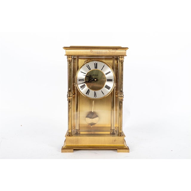 A brass French Regulator style mantel clock, branded "Benchmark" in a rectangular case with four beveled glass panels,...