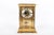 A brass French Regulator style mantel clock, branded "Benchmark" in a rectangular case with four beveled glass panels,...