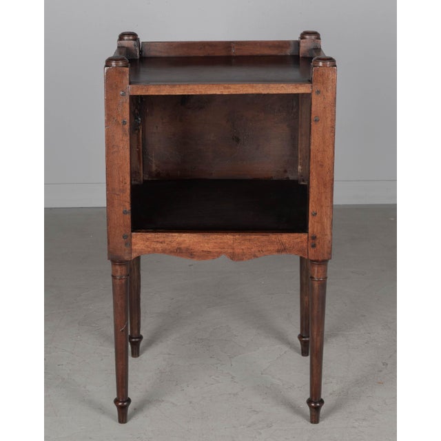 A 19th century Country French side table or nightstand made of solid walnut, with pierced heart shaped cut-outs on the...