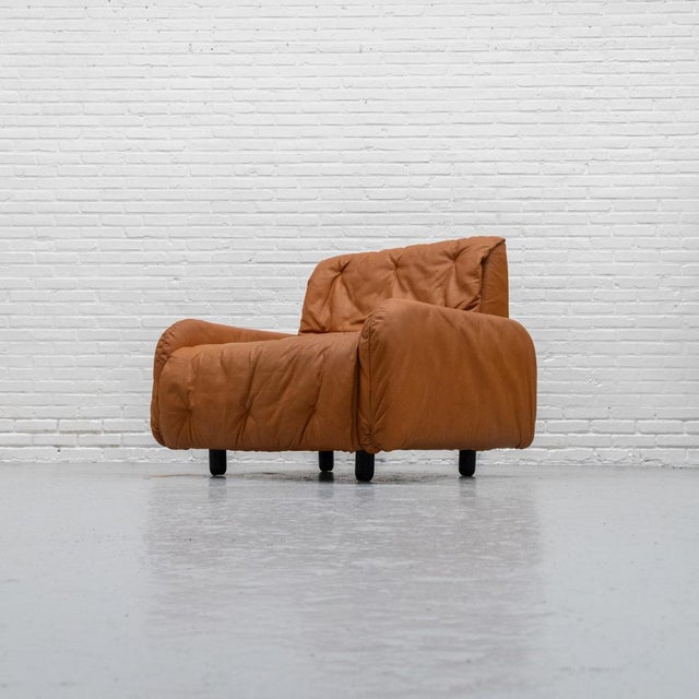 Rare Italian armchair by Bonacina from the 1970s, featuring a soft, enveloping shape and upholstered in cognac-colored...