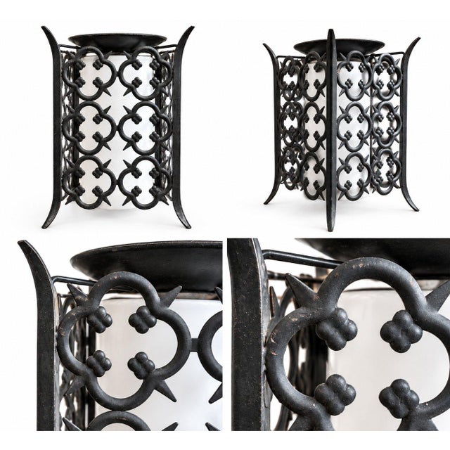 Decorative Gothic Revival-style ceiling light fixture featuring an ornate black metal frame with quatrefoil motifs and a...
