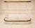 A white lacquered iron baker's shelf with three shelves featuring oval and semi-oval profiles, circa 1900. Each shelf has...