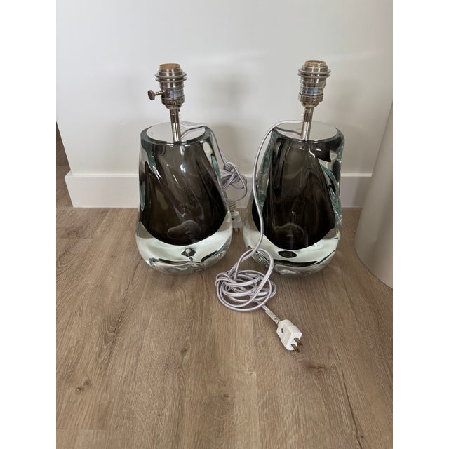 A pair of artisanal hand-blown glass table lamps by the renowned British studio Porta Romana. These "Obsidian" or smoke-...