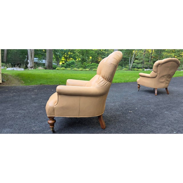 Pair of transitional style club chairs by Ethan Allen, manufactured in 1990s. Fully upholstered in leather with tufted...