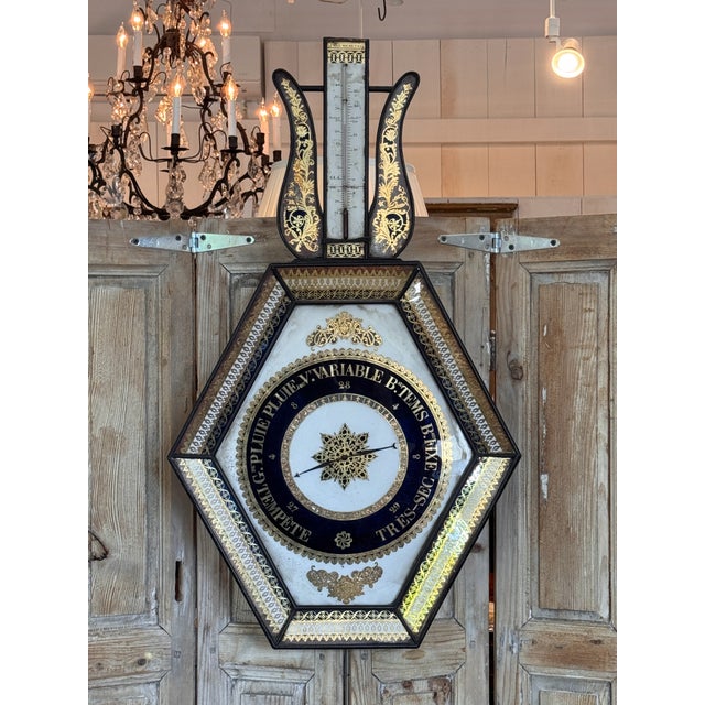 A 19th century French barometer, the six-sided case faced with eglomise glass panels — gilt scrollwork and lacework...