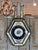 A 19th century French barometer, the six-sided case faced with eglomise glass panels — gilt scrollwork and lacework...