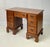 A Chippendale style solid walnut kneehole desk featuring an arrangement of seven dovetailed drawers and tall straight...