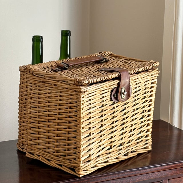 A lovely mid-20th century wicker picnic basket with original textile lining. This basket features a lid secured by wire...