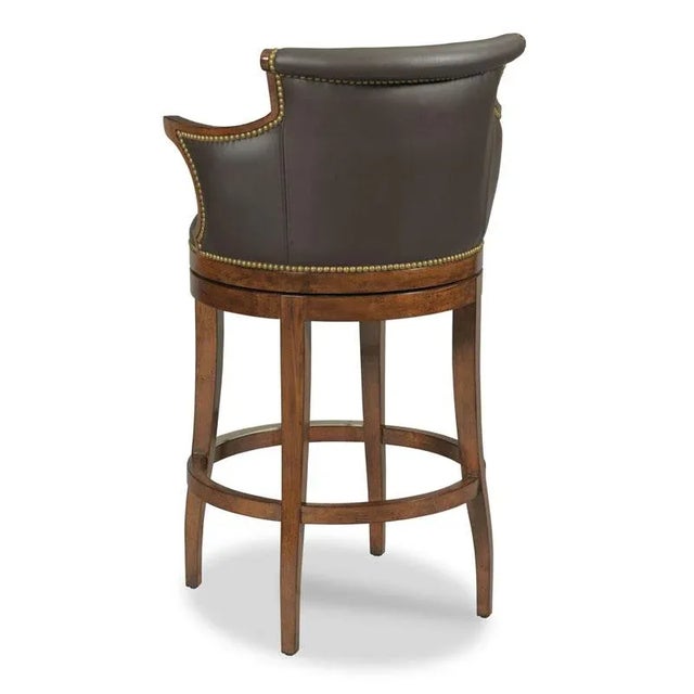 Shaped tapering legs support an upholstered seat below an upholstered barrel back and arm. Care Instructions: Our wood...