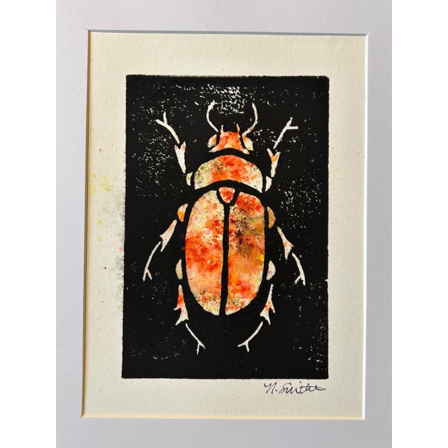 An original hand-carved block linocut featuring a detailed beetle motif, individually printed with black ink and finished...