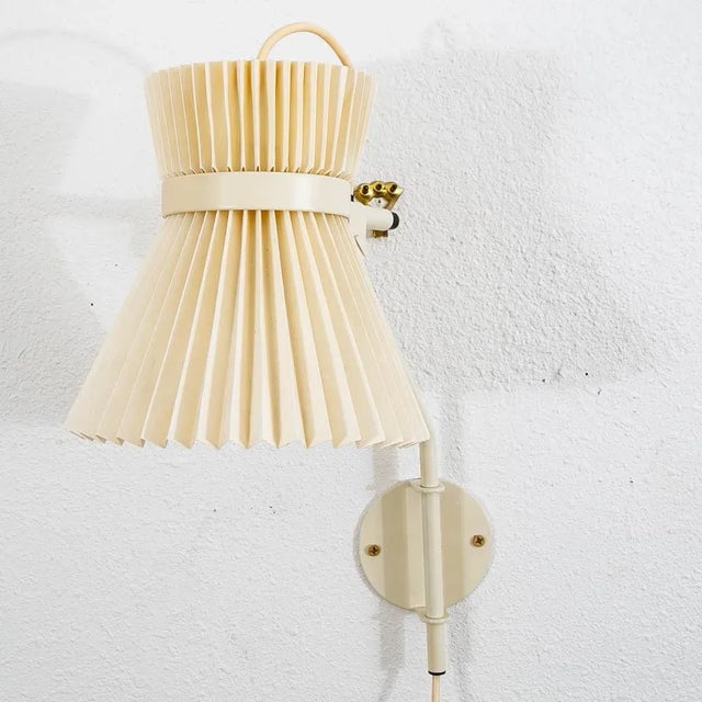 Adjustable wall sconce by Le Klint. Comes with a pleated plastic shade. The lamp can be rotated from up to down and...