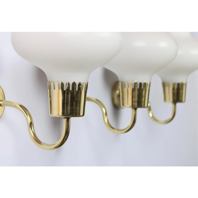 Beautiful set of three wall sconces in mouth-blown opal glass and solid brass. Produced in Denmark in the 1950s and...