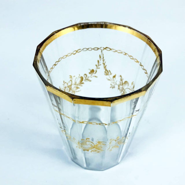 Antique Bohemian gilded glass cup from the 18th century. It has a polygonal shape with 13 sides and a gilded rim, a...