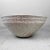 This beautiful glazed ceramic bowl features an organic design with a wavy raised edge. The surface of this ceramic...