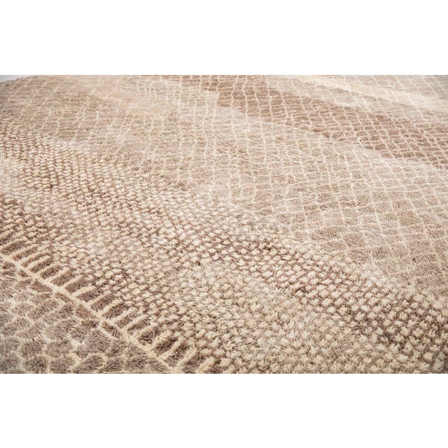 Sophisticated hand-knotted wool rug in Deep Taupe, Light Taupe, and Ivory, featuring a layered composition of intricate...