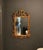 Striking vintage gilt wall mirror with an elaborate Rococo and Chinese Chippendale-inspired silhouette. The sculptural...