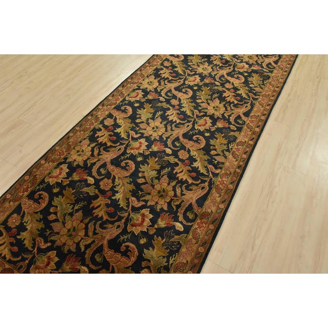 A traditional Agra runner hand-knotted with an all-wool pile on a cotton foundation. This finely woven oriental rug...