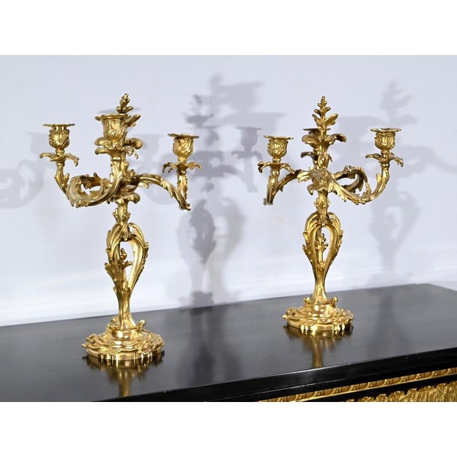 Pair of bronze candelabra with golden patina, with three lights, dating from the end of the 19th century. The arms,...