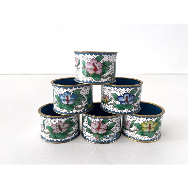 Set of 6 early 20th century cloisonné napkin rings. Set on a white base with lovely gold swirls and colorful blossoms and...