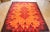 This rug in brown, orange, and red colors was made in Italy in the 1970s.