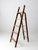 An early 20th century wooden folding ladder with a richly layered, timeworn surface and sculptural presence. Remnants of...