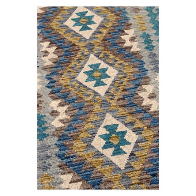An elegant vintage Afghan kilim, handcrafted from wool, featuring refined tribal geometric patterns and a sophisticated...