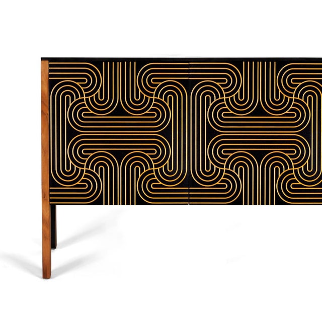 The loop sideboard three door with black doors and a carved pattern hand painted in gold. this piece will add a...
