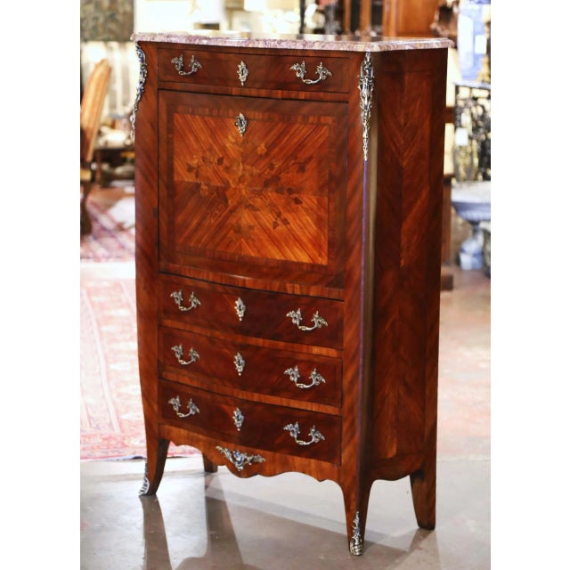 Graceful serpentine lines and intricate marquetry give this antique secrétaire à abattant its refined Louis XV character....