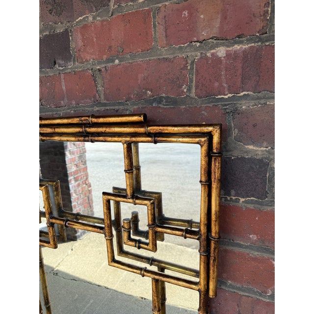 Exceptional vintage LaBarge wall mirror featuring a sculptural faux bamboo frame in a warm antiqued brass finish. This...